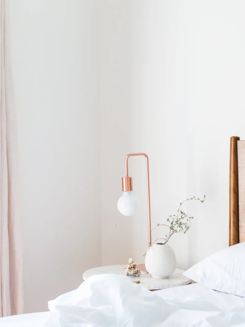 Une chambre claire de La Grande Bastide, lampe de laiton et linge blanc