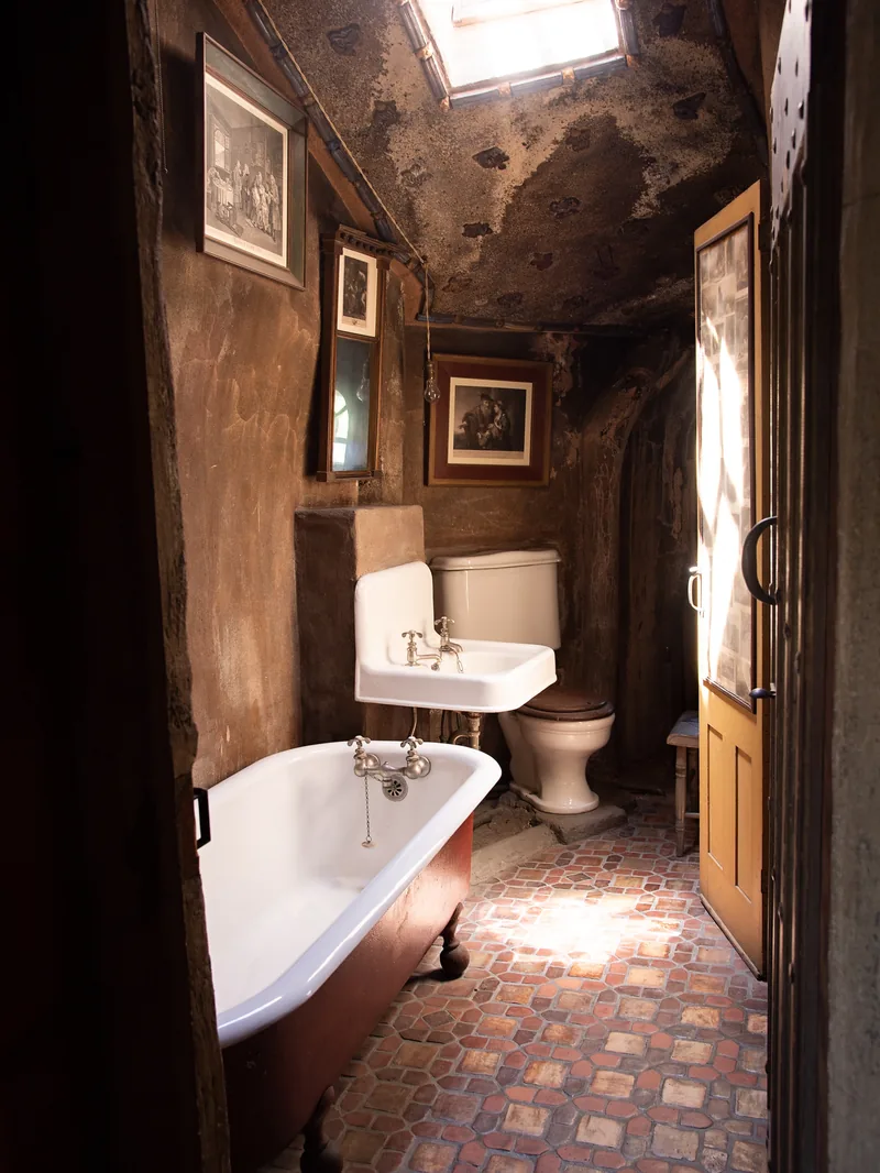 Salle de bains ancienne de La Grande Bastide, baignoire sur pieds et sol en tomettes