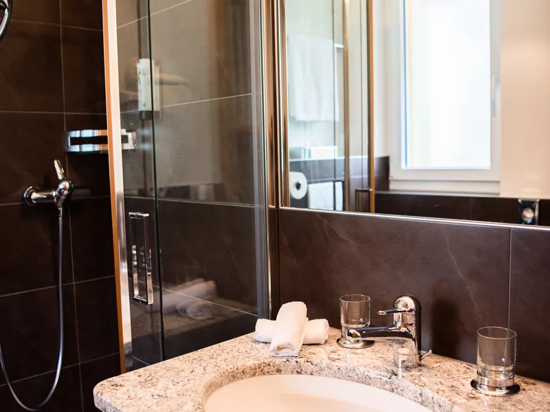 Une salle de bains de la Villa des Pins, vasque sur plan en granit et douche vitrée