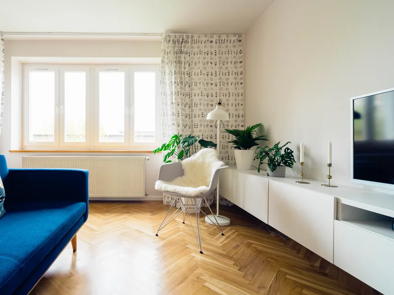 Le séjour lumineux de l'Appartement Plage, canapé bleu et parquet à bâtons rompus