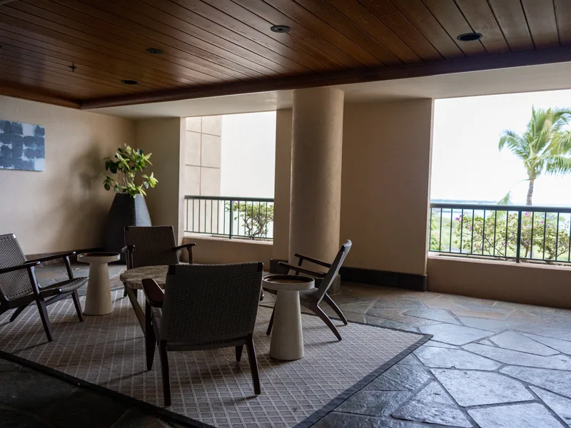 La terrasse couverte de l'Appartement Plage, fauteuils face aux palmiers