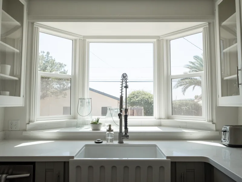 La cuisine de l’Appartement Plage, évier sous la fenêtre en baie