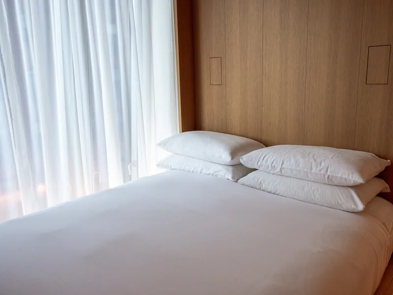 Une chambre de l'Appartement Plage, lit blanc et voilages