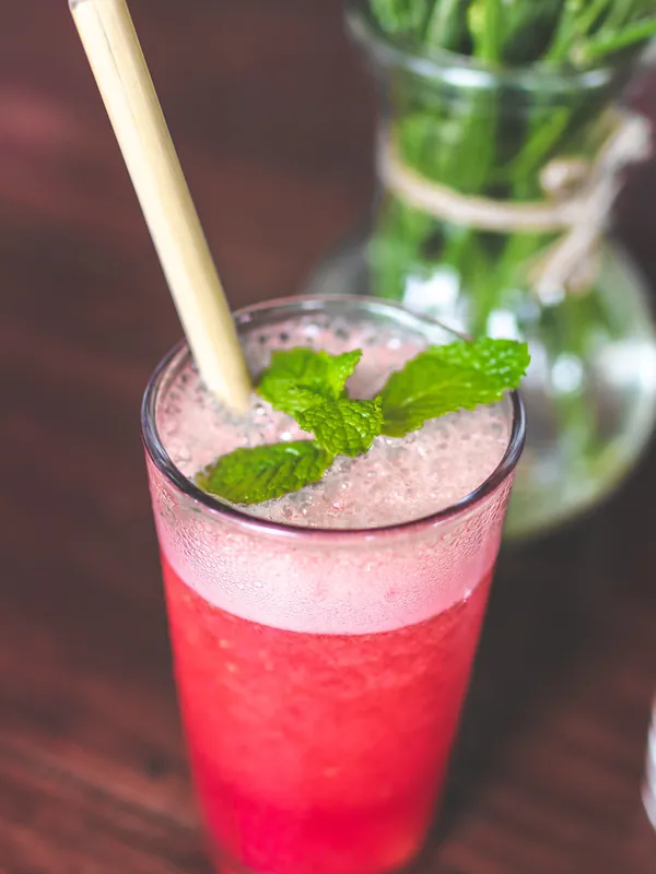 Verre de limonade à la framboise avec menthe fraîche et paille